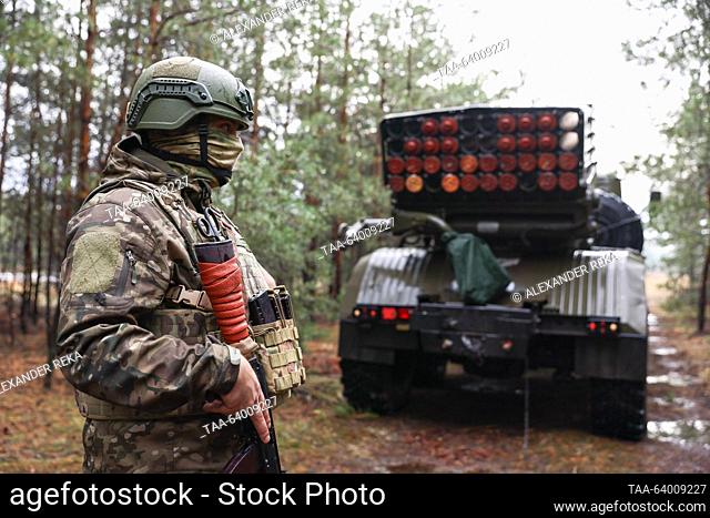 RUSSIA, LUGANSK PEOPLE'S REPUBLIC - OCTOBER 27, 2023: A crewman stands guard near a BM-21 Grad multiple-launch rocket system in the Krasny Liman sector of the...