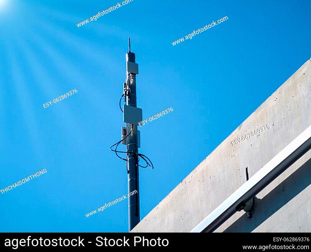 Antenna mast (communication-based train control system) for electric train and lens flare white. Blue background