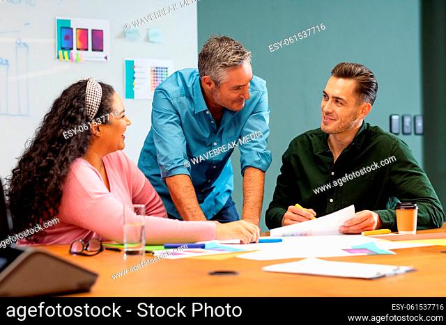 Businessman explaining business strategy to multiracial colleagues in meeting at creative office