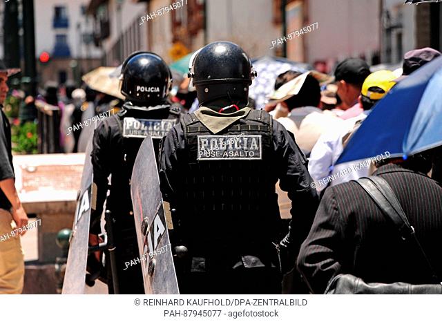Out and about in the old capital of the powerful Inca empire and the later colonial town of Cuzco. Police officers with protective shields and helmets follow a...