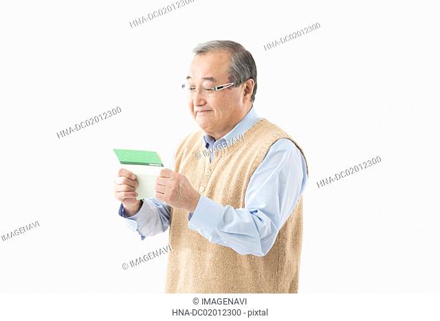 Senior man looking at passbook with smile