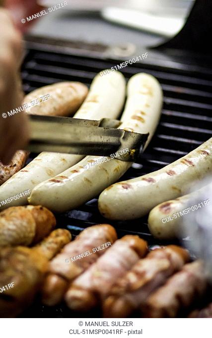 Close up of sausages cooking on grill