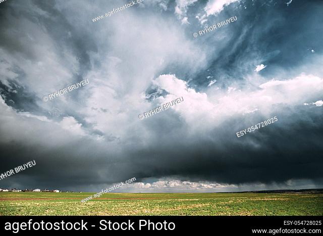 Countryside Rural Field Spring Meadow During Rain. Rain Clouds On Horizon. Agricultural And Weather Forecast Concept