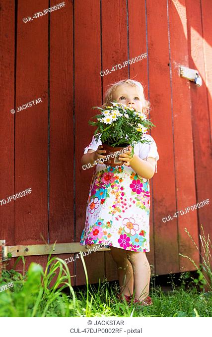 Girl holding potted plant outdoors