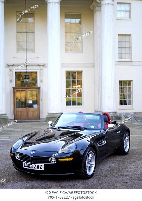 A BMW Z8 Alpina Roadster parked in the driveway of a mansion