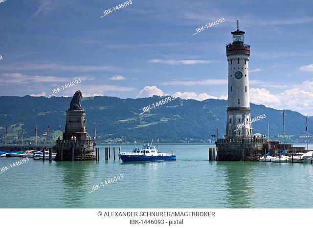 Harbor entrance of Lindau on Lake Constance with the Bavarian lion and the lighthouse, with a boat of the water police, looking towards Bregenz with its local...