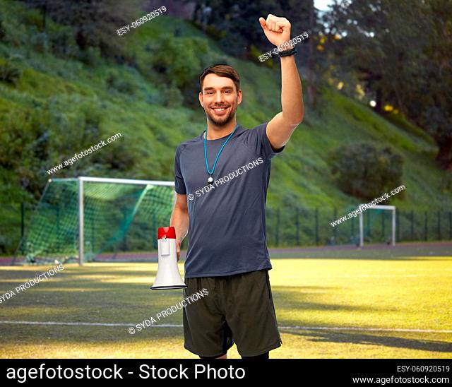 happy soccer coach with megaphone on playground