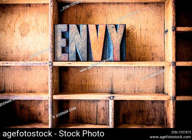 The word ENVY written in vintage wooden letterpress type in a wooden type drawer