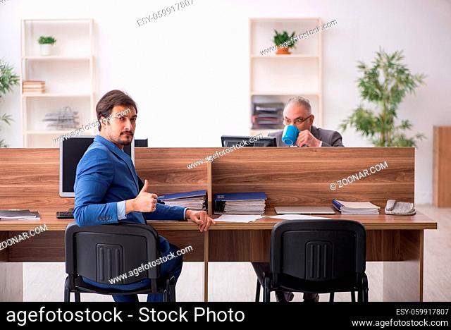 Two male employees working at workplace