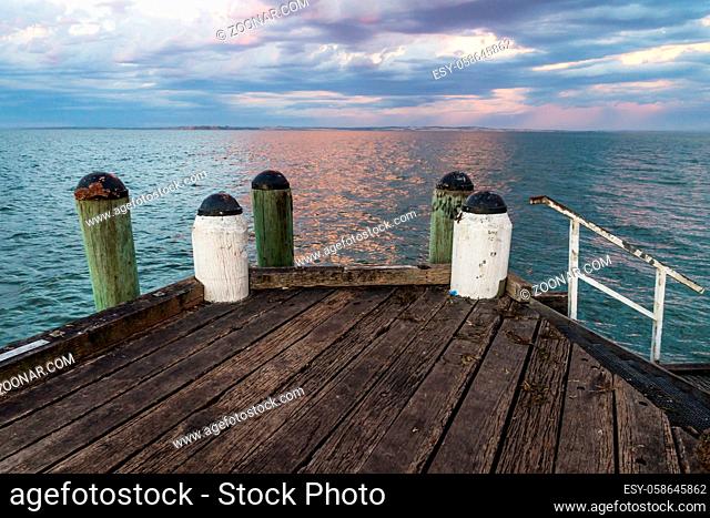 Sunset at the wooden jetty with green and white pillars of Cowes, Phillip Island, Australia