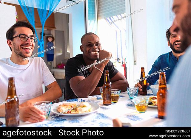 Amigos varones socializando con comida y cerveza