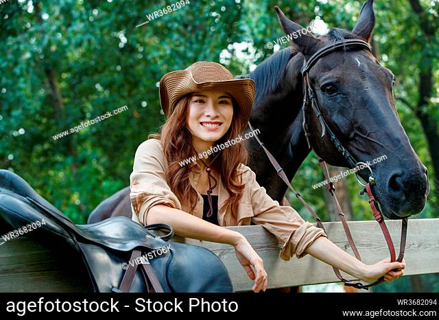 Lie prone on the fence and happy young woman the horse