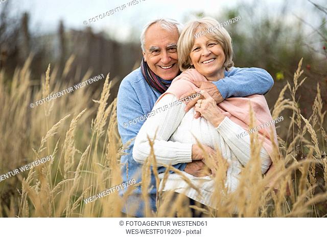 Happy senior holding his wife in his arms