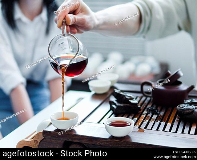 Chinese tea ceremony. Master pouring puer tea in cups. Pu erh tea ceremony