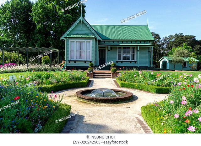 a small green house in rotorua government gardens with flowers surrounding. Taken in rotorua, new zealand during summer