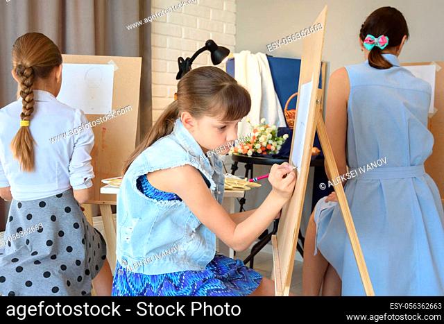 Children are engaged in an art studio with an artist