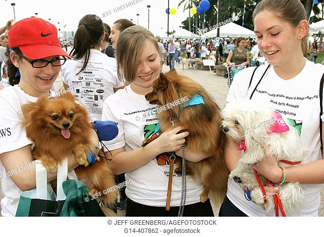 Dogs, female teen volunteers. Walk for the Animals, Humane Society event, Bayfront Park, Miami, Florida. USA