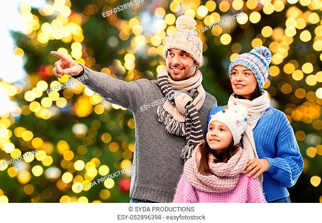 happy family in winter hats over christmas lights