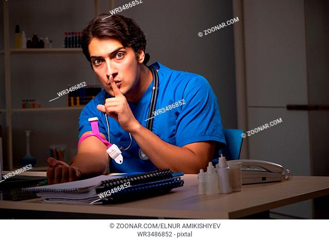 Young handsome doctor working night shift in hospital
