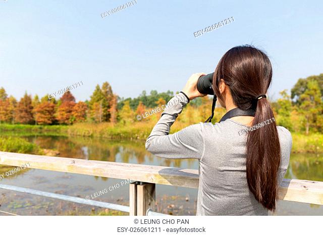 The back view of Asian Young woman use of the binoculars