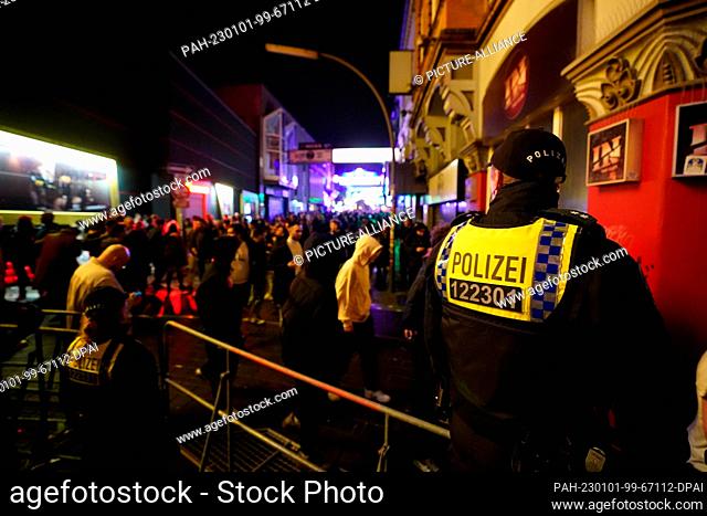 01 January 2023, Hamburg: Police officers control access to the Grosse Freiheit on New Year's Eve in the St. Pauli district. Photo: Marcus Brandt/dpa