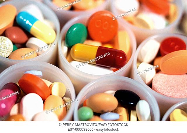 Assorted medicine pills in opened plastic bottles