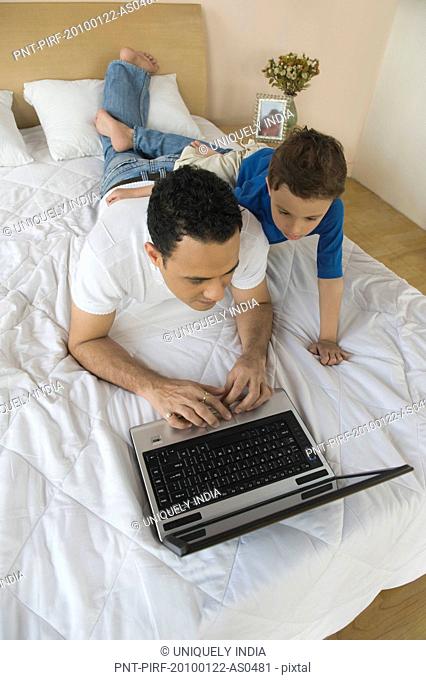 Man and his son using a laptop