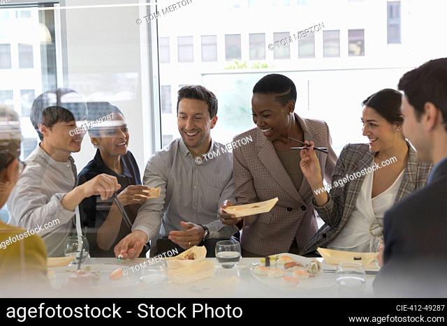 Happy business people enjoying sushi lunch