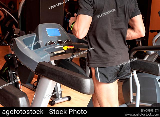 Man running in a modern gym on a treadmill, concept for exercising, fitness and healthy lifestyle
