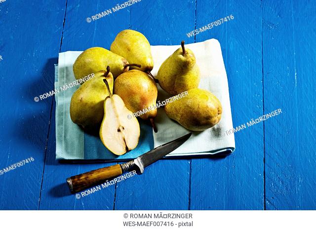 Williams pears and knife on blue wooden table