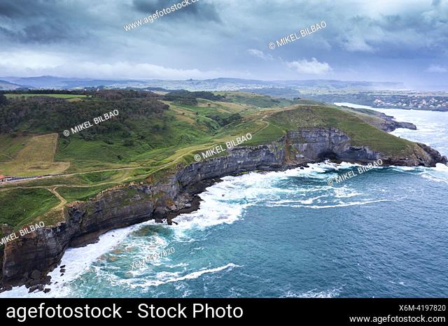 Aerial view of a coastal landscape with rocky cliffs and green meadows. Cantabria, Spain