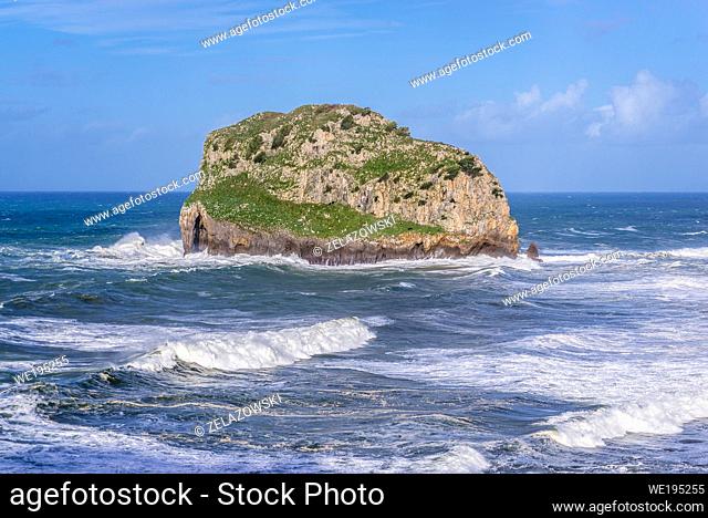 Small Aquech rocky islet also called in Basque Aketx next to Gaztelugatxe isle on the coast of Biscay province near Bermeo town, Spain