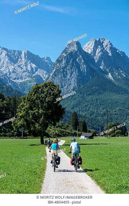 Cyclists on bike tour, cycle path with mountain bike, behind Zugspitze, Tegernauweg, near Grainau, crossing the Alps, Garmisch-Partenkirchen, Upper Bavaria