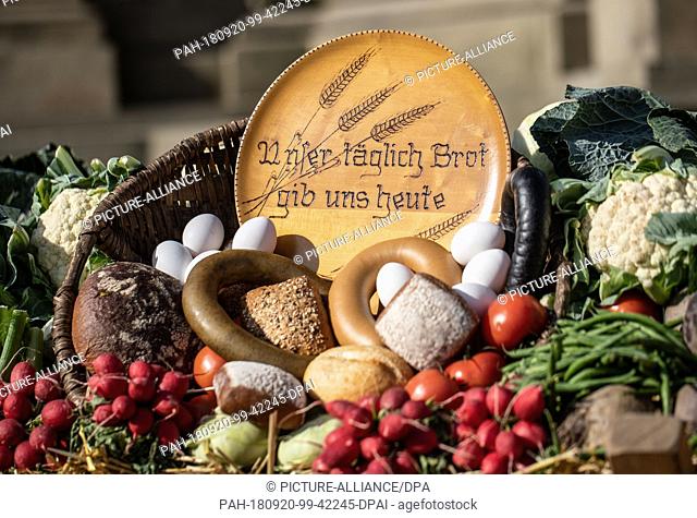 20 September 2018, Hessen, Frankfurt-Main: A wooden plate with the words ""Give us our daily bread today"" is set up at the 35th Frankfurt Harvest Festival in...
