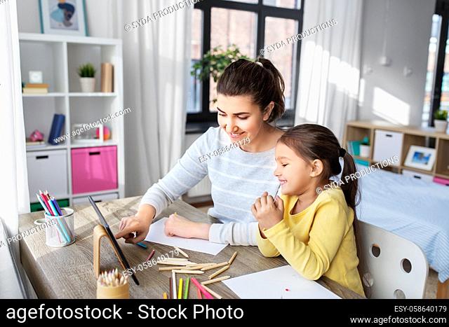 mother and daughter with tablet pc drawing at home