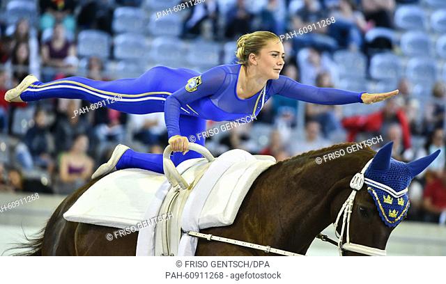 A member of the Swedish team ""Svea Vaulting"" performs in the Vaulting Squads Compulsory Test during the FEI European Championships in Aachen, Germany