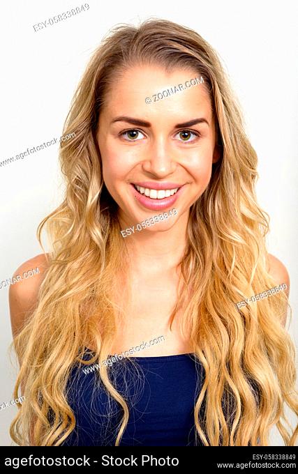 Studio shot of young beautiful woman with blonde wavy hair against white background