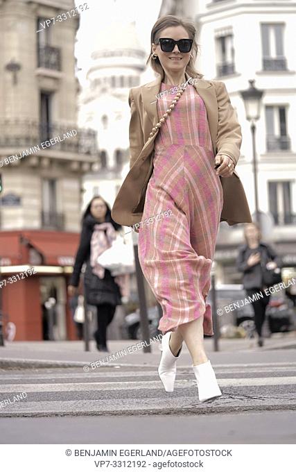 fashionable blogger woman running at street in front of touristic sight Basilica Sacré-Cœur, during fashion week, in city Paris, France
