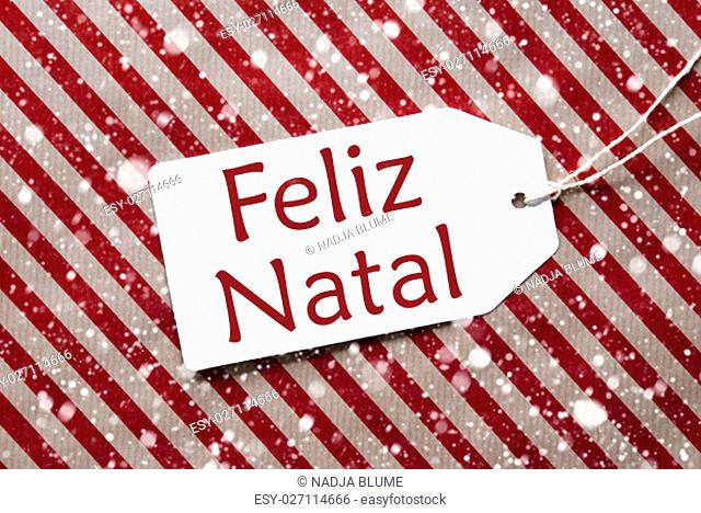 One Label On A Red And Brown Striped Wrapping Paper. Textured Background With Snowflakes. Tag With Ribbon. Portuguese Text Feliz Natal Means Merry Christmas
