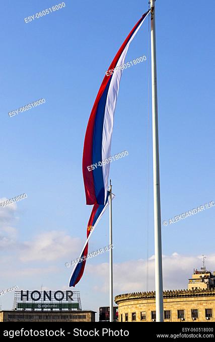 BELGRADE, Serbia - November 15, 2021 - National flag of Serbia on the high pole waving in the wind in front of National Assembly building in Belgrade, Serbia