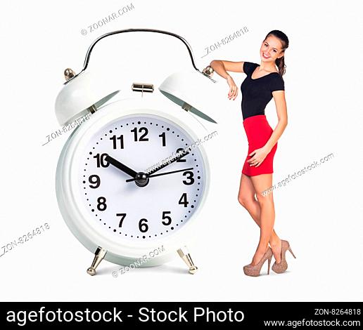 Business woman stands near big white alarm clock isolated on the white