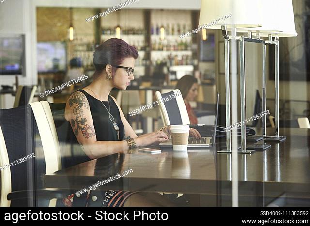 Caucasian woman using laptop in coffee shop