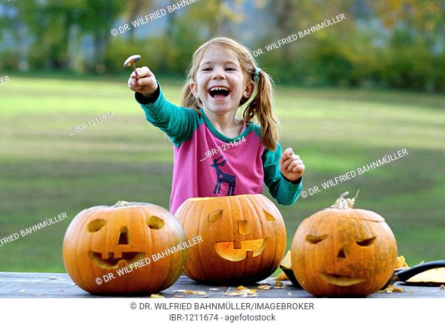 Girl carving a jack-o-lantern from a pumpkin for Halloween