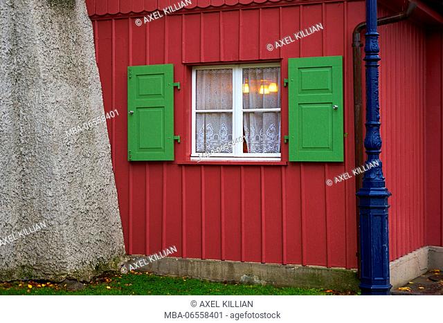 Red house, window with with green shutters, illuminated