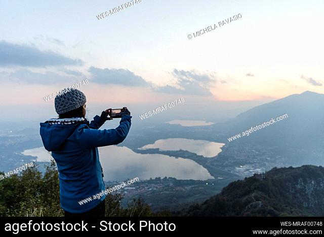 Hiker photographing though smart phone on mountain