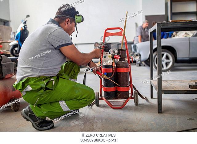 Man preparing welding jig in bodywork repair shop