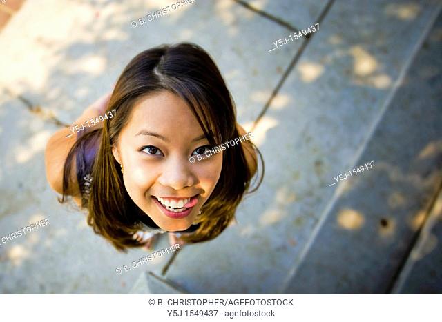 Young Asian female looking up with tongue out