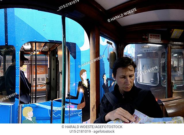 Hong Kong, China, Asia. European female tourist reading a map while on a tram on Hong Kong Island