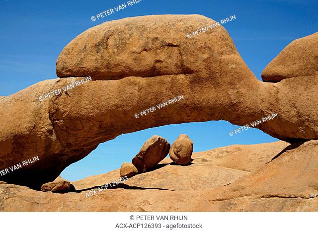 The famous natural bridge at Spitzkoppe, formed from volcanic rock during may millenia of erosion. Central Namibia. Africa