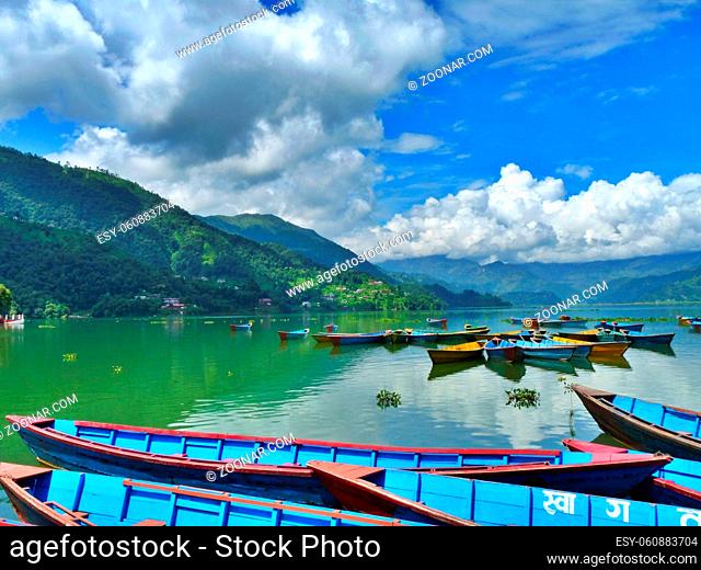 Blue boats on lake, Pokhara, Nepal, mountains and bright blue sky. High quality photo